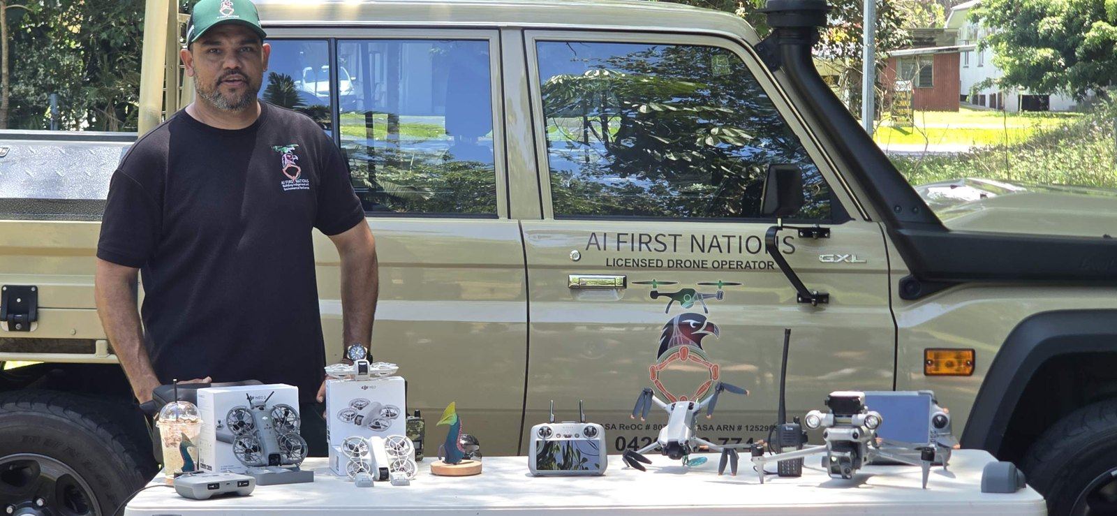 John standing beside the AI First Nations LandCruiser with a table of DJI drones and controllers